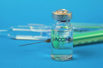 Medicine bottle for injection with medical vials for vaccination on the background on the blue...
