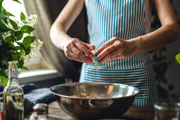 A woman is breaking an egg to make dough. Making handmade pasta in a pleasant and cozy home environment