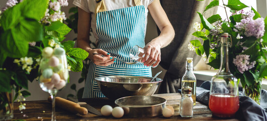 A woman is preparing fresh dough in a cozy atmosphere. Concept of cooking delicious dough dishes at home.