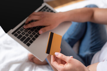cropped view of man using laptop and woman holding credit card