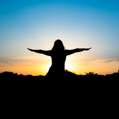 Fototapeta premium silhouette of woman doing yoga in the sunset