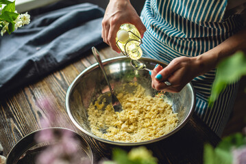 A woman is preparing fresh dough in a cozy atmosphere. Concept of cooking delicious dough dishes at home.