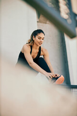 Young attractive smiling caucasian sportswoman tying shoelace and preparing for running.