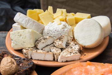 A plate with various cheeses; goat cheese; cow cheese; food in clay plate during medieval festival; Mediterranean food 