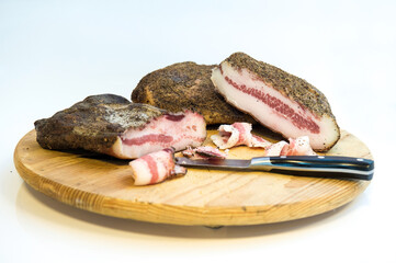  bacon called guanciale in Italy  isolated on wooden chopping board isolated on white background