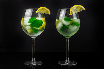 Refreshing summer cocktail of lemon, lime and ice cubes. Black background