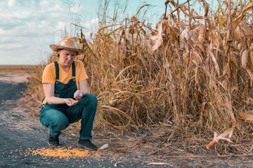 Disappointed female corn farmer in cornfield after poor harvest