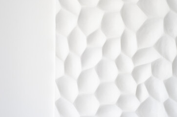 White wall with a wavy texture. Gypsum panels with geometric patterns. Embossed wall in neutral...