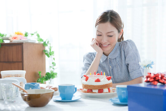 ケーキを笑顔で見つめる20代女性