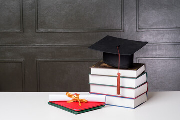 Graduation cap with books on white desk , Education background
