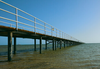 Fototapeta premium bridge on the shore of the beautiful sea goes to the horizon