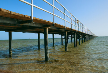Obraz premium bridge on the shore of the beautiful sea goes to the horizon