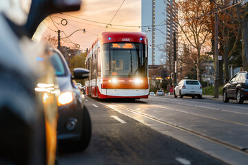 A streetcar approaches on a Toronto street at sunset