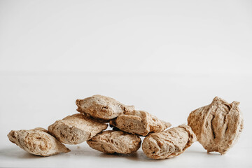 Raw dehydrated soy meat or soya chunks on a white wooden background. Copy, empty space for text