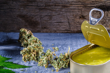 marijuana buds. medical cannabis butter in a open tin can. hemp leaves. horizontal orientation. on...