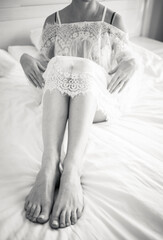 Black-white photo of bride's legs close up