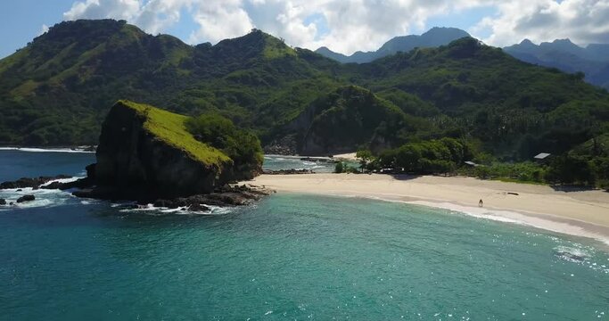Breathtaking view of Koka beach, with its waves, clear blue water, white sand and mountains on Flores island, must-see destination in East Nesa Tenggara, Indonesia and Asia