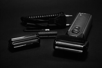 Rechargeable electric shaver for men, black background.