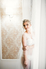Naklejka na ściany i meble Luxury bride in white dress posing while preparing for the wedding ceremony