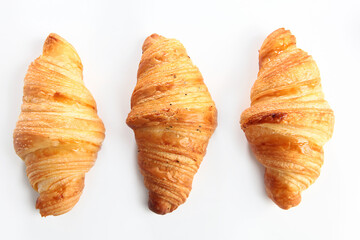 Three croissants on a white background. An isolated object. Top view. Copy of the space