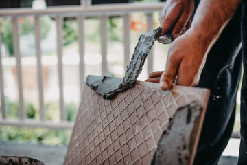 skilled worker installing the ceramic wood effect tiles on the floor Worker making laminate flooring on the construction site of the new apartment