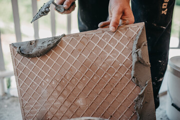 skilled worker installing the ceramic wood effect tiles on the floor Worker making laminate flooring on the construction site of the new apartment