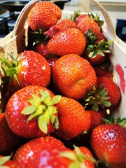 Close up of a punnet full of red delicious strawberries. Symbols of spring. Eco dessert concept background