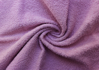 Fototapeta na wymiar Wrinkled fabric texture material background. Light purple or violet colour crumpled bedsheet, wavy curved linen furry fabric backgrounds with creased spiral pattern