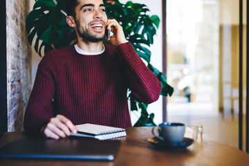  Bearded cheerful man using modern technology with high speed internet