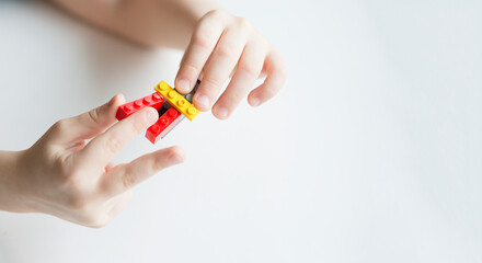 hands fingers boy playing Bricks isolated on white background copy space for text. Concept simple task. Child cope. motor skills. How to entertain child. Bright detail. Handle it. From simple to complex