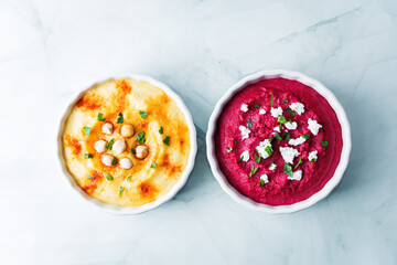 Set of classic hummus and beet hummus appetizers with carrot, radish, tomato and cucumber