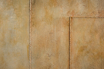 Textured rusty metal background. Decorative plaster. Interior wall decoration. Imitation of an old wall close-up.