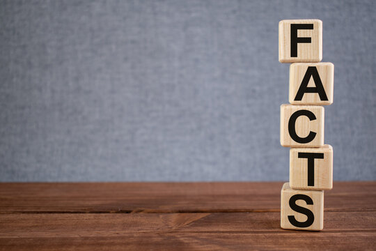 Word FACTS text on wooden cubes on dark wooden backround. Business, Marketing, Information concept.