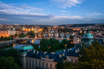 Night in Prague from Letna park with Straka academy in the foreground. View of bridges over Vltava with Charles bridge. Czech Republic.