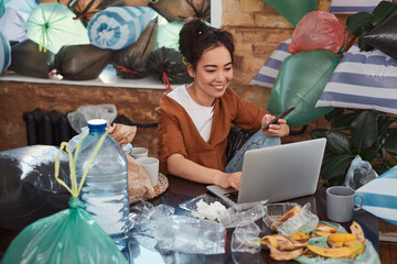 Young female using computer and smartphone in a messy room © Yakobchuk Olena