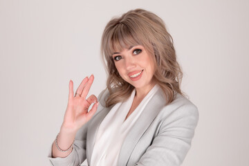 Portrait of woman business blonde in a bright jacket on a white grey background