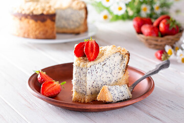 Homemade poppy seed cheese cake in a ceramic plate on a wooden background