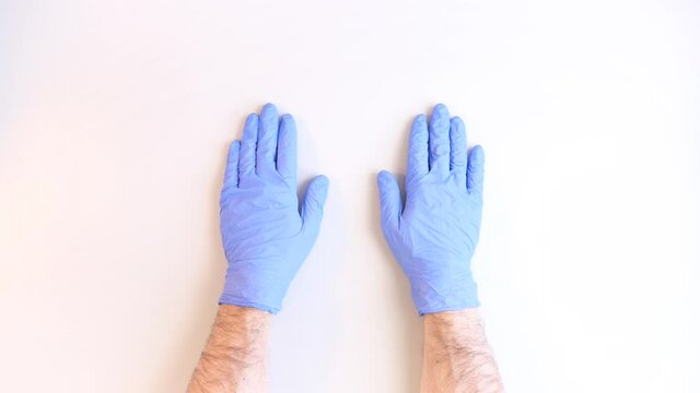 Men's hands taking off blue disposable gloves medical