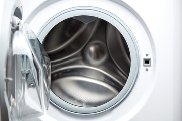 Open white washing machine close-up.