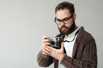 Confident hipster photographer with camera isolated on white