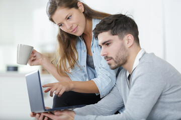 couple relaxing at home looking at a laptop