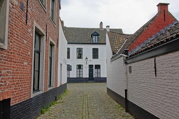 Fototapeta na wymiar Streets with white painted brick houses of the Holy corner or Old Saint Elisabeth beguinage, Ghent.