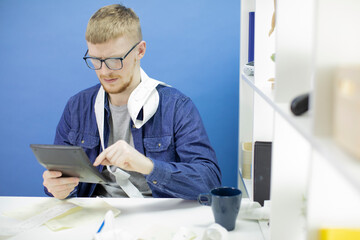 Caucasian male using calculator and counting budget, expenses and savings. Home budget planning. Payment of loans and mortgages concept. Isolated on blue background.