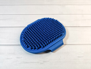 Soft blue rubber massage brush for animals. Pet care accessories. Hand-held massage brush to remove...