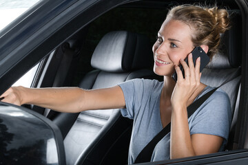 beautiful young woman on the phone while driving her car