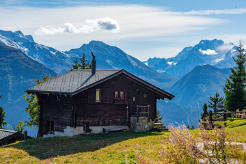 Fototapeta na wymiar Idyllic landscape in Swiss Alps with chalet and mountains on background, Bettmeralp, Canton of Valais, Switzerland