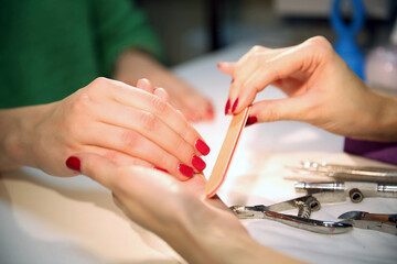Obraz na płótnie Canvas Red manicure. Hand and nail care in a beauty salon. Spa treatment