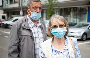 senior couple wearing medical masks on the street