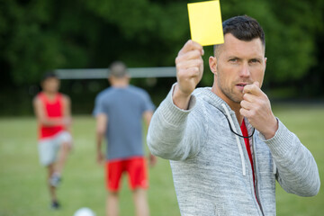 football referee showing yellow card