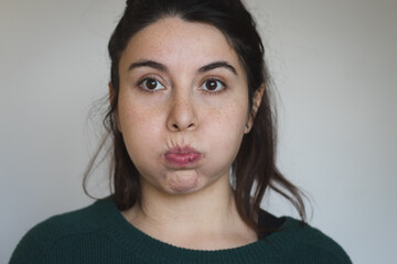 Blowing ckeeks gesture woman